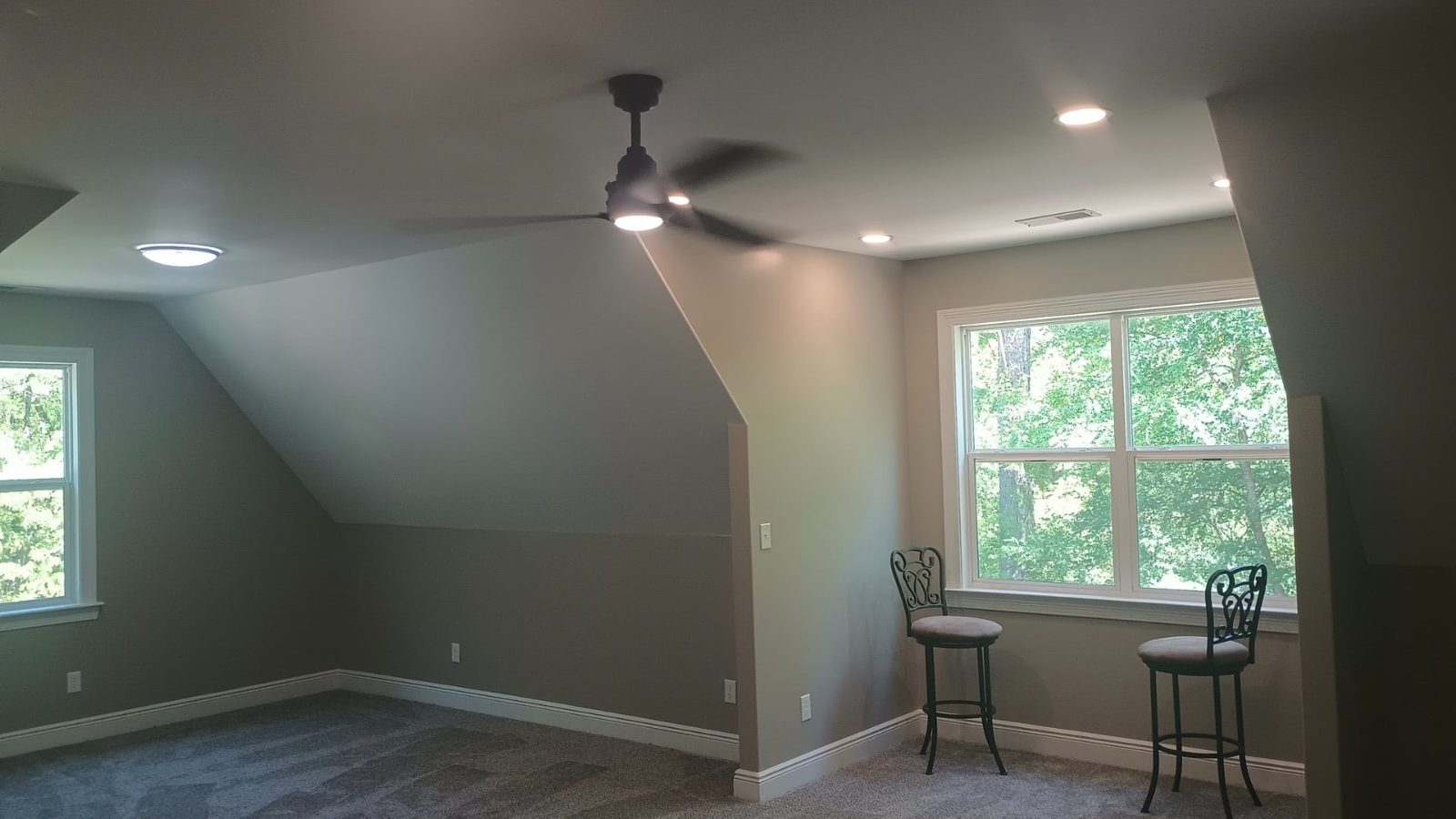Ceiling fan and recessed lighting installed in a finished bonus room.