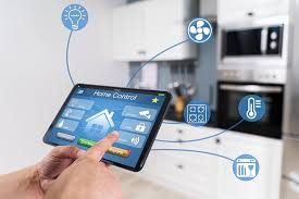 A hand controlling home lighting, climate, and appliances from a smart tablet in a kitchen.